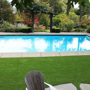 artificial grass installed in backyard beside pool