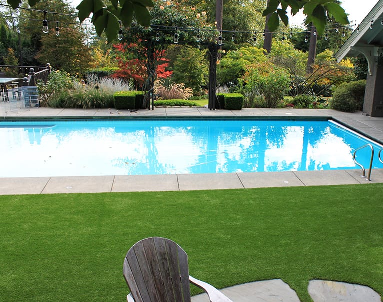 artificial grass installed in backyard beside pool