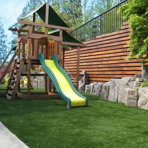 childs playground on artificial grass lawn in residential backyard