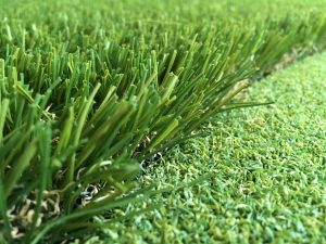 close up photo of artificial grass edge against artificial putting green grass