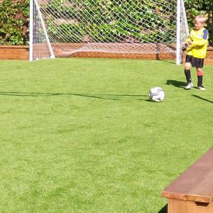 child playing soccer on artificial grass sports field