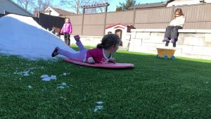 kids playing in snow covered artificial grass in canada winter